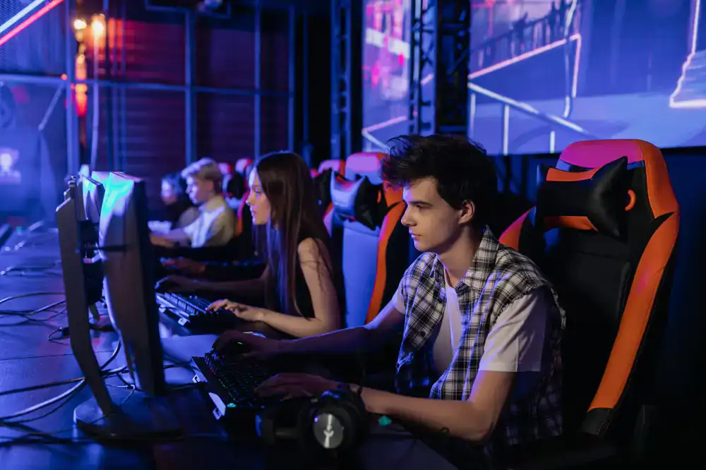Gamers playing consoles at a busy evening event