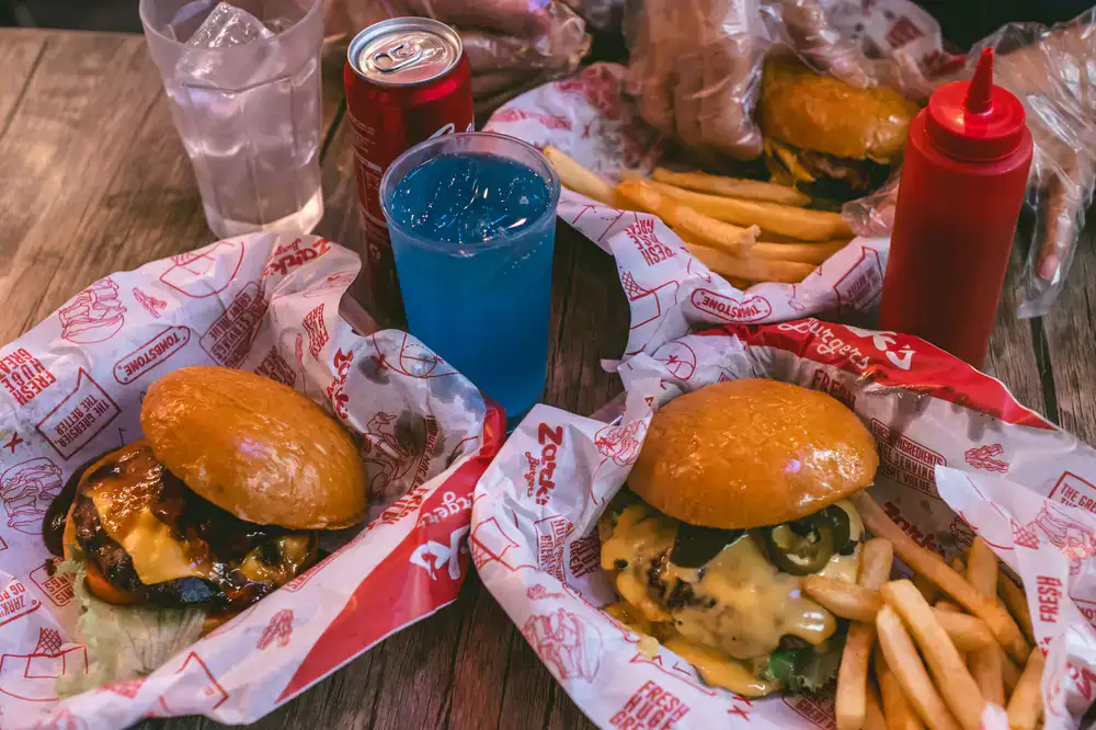 Artisan burger and a colorful iced drink on a tray